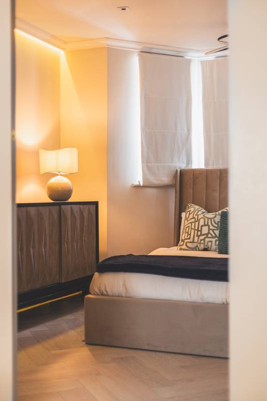 Upholstered headboard and bedside lamp in bedroom one