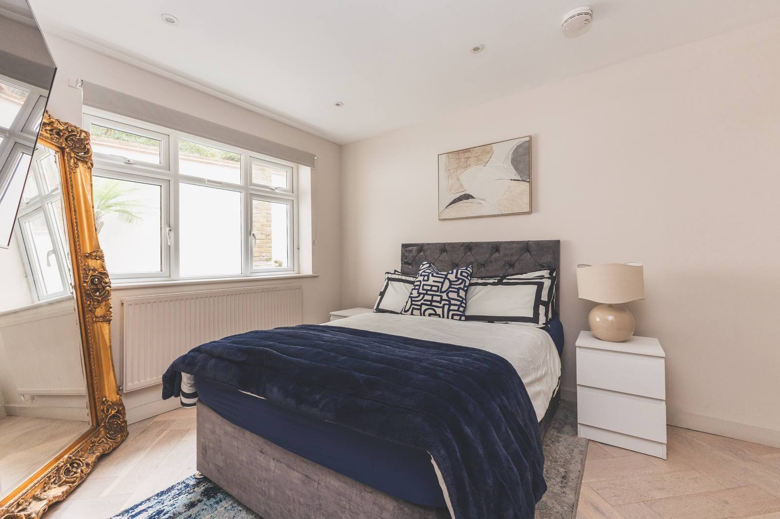 Bedroom two with a double bed and a gilt mirror